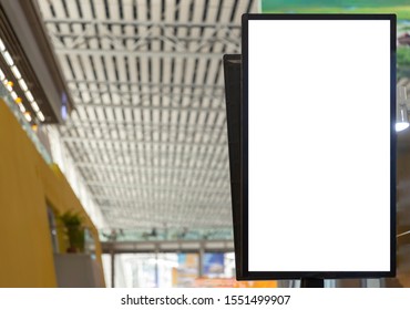 Close Up View Of Vertical Blank White Advertising TV Screen With Blurry Shopping Mall Interior Ceiling.