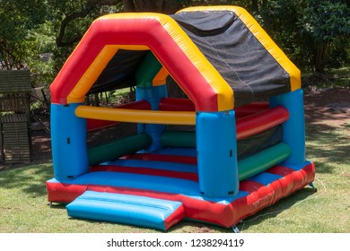 A Close up view of a very colourful blown up jumping castle in the back garden  - Shutterstock ID 1238294119