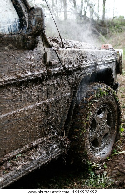 close of view of a very muddy car after off road\
driving through the dirt and\
mud.