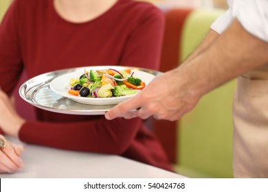 Close Up View Of Waiter Serving Salad At Restaurant