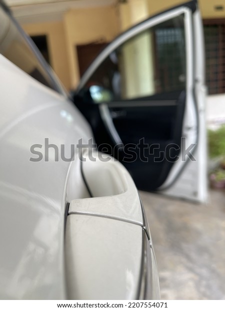 Close\
up view of a white car door with blurry\
background
