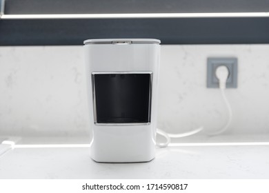 Close Up View Of White Kitchen  Counter With Plugged Turkish Coffee Machine With Grey Window Background. Copy Space For Text Area.