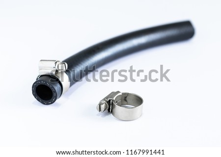 Close up view of Wire hose clamp strap with black rubber tube isolated on white floor.