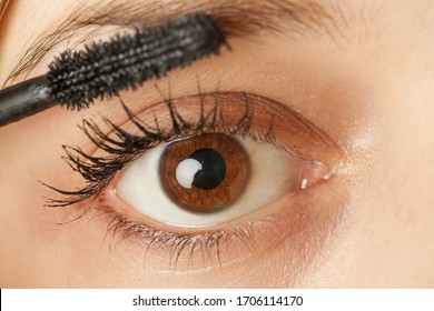 Close up view of a woman eye and mascara wand