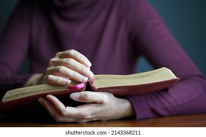 Close up view of woman holding an open Bible. - Powered by Shutterstock