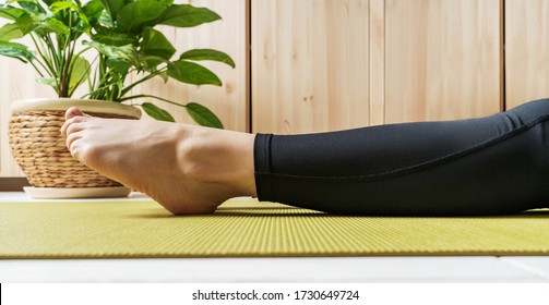 Close View Of Woman Legs On An Exercise Mat. Female Preparing Practicing Yoga At Home. National Yoga Day. Healthy Living In Lockdown.