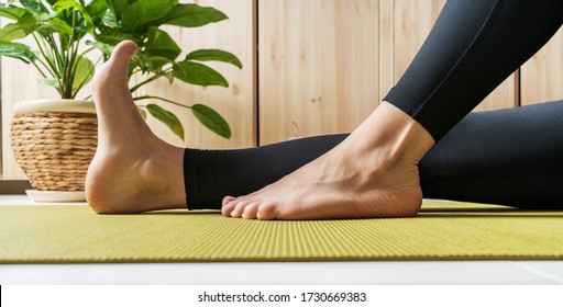 Close View Of Woman Legs On An Exercise Mat. Female Preparing Practicing Yoga At Home. National Yoga Day. Healthy Living In Lockdown.