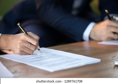 Close up view of woman and man signing document concluding contract concept making prenuptial agreement visiting lawyer office, female and male partners or spouses writing signature on decree paper - Shutterstock ID 1289761708