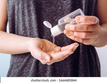 Close up view of woman person using small portable antibacterial hand sanitizer on hands. - Shutterstock ID 1664685844