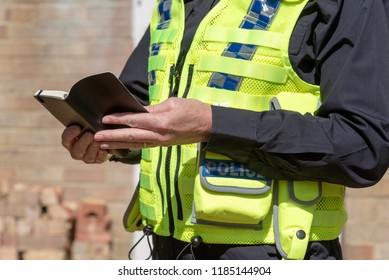 Close Up View Of A Woman Police Officer Holding An Open Black Notebook,