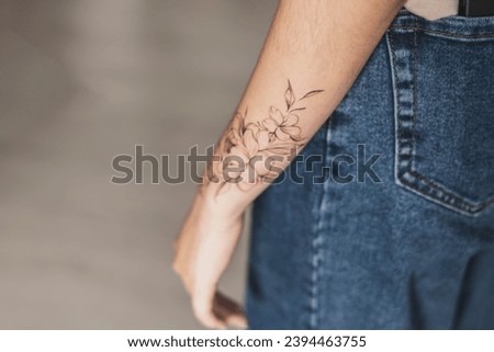 a close up view of woman showing her finished flowers tattoo on her hand