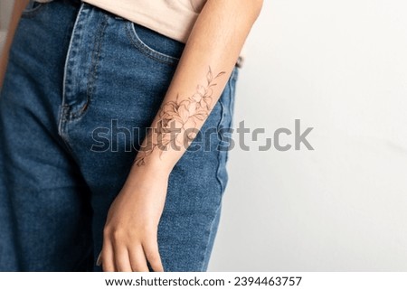 a close up view of woman showing her finished flowers tattoo on her hand