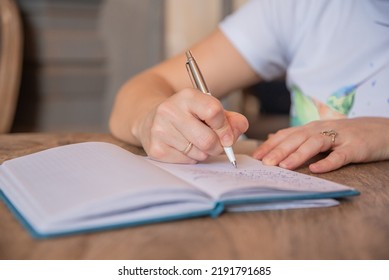 Close Up View Of Woman Sit At Table Hold Pen Take Notes To Paper Notebook Working Studying. Female Student Businesswoman Employee Write Records To Daily Planner By Hand At Home Work Desk