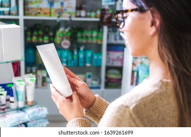 Close Up View Woman In Store Holding A White Jar Reading The Label. Be Careful What You Buy