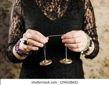 Close up view of woman using traditional Tibetan Tingsha bells (or Ting-Sha). Alternative sound therapy concept. Used in prayer and rituals.