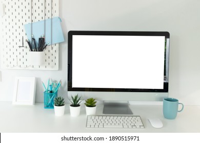 Close up view of workplace with computer, camera on white table.