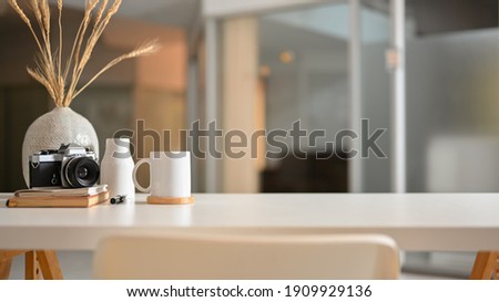 Close up view of worktable with camera, stationery, plant vase and copy space on the table in living room