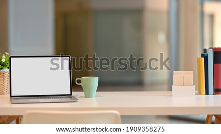 Close up view of worktable with laptop, books, mug and copy pace in living rom, clipping path