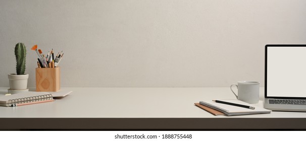 Close up view of worktable with laptop, notebooks, stationery and copy space in home office room
