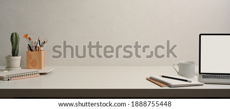 Close up view of worktable with laptop, notebooks, stationery and copy space in home office room