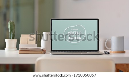 Close up view of worktable with laptop, stationery, decorations and stationery in living room