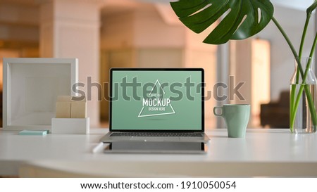 Close up view of worktable with laptop, tablet, stationery and decorations in living room
