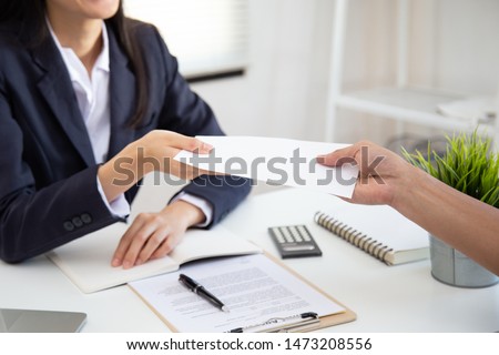 Close up view of Young Asian business woman receiving salary or bonus money from boss or manager at office happily.