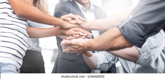 Close up view of young business people putting their hands together. Stack of hands. Unity and teamwork concept. - Powered by Shutterstock