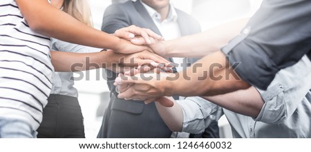 Close up view of young business people putting their hands together. Stack of hands. Unity and teamwork concept.