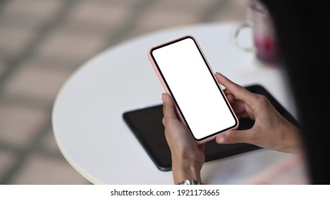 Close Up View Young Female Holding Smart Phone With White Screen As Sitting At Cafe. Blank Screen For Your Advertising Text.