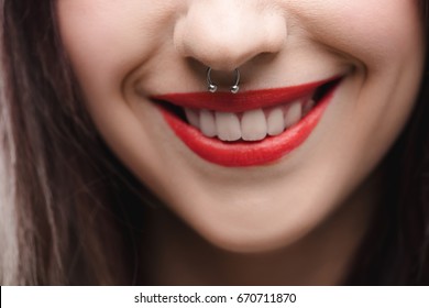 close up view of young girl with red lips and piercing in nose