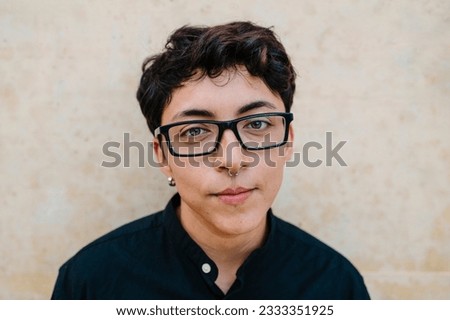 Close up view of a young transgender man looking at camera and smiling.