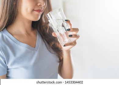 Close Up View Of Young Woman Drinking Pure Mineral Water In A Glass.