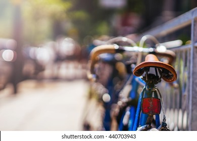 Close up of a vintage bicycle seat with a colorful background bokeh made of busy traffic. Summer day, sunny. Shallow DOF.