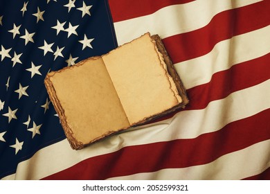 Close Up Vintage Book Blank Yellow Paper Pages On Old Weathered Cotton Embroidered US National Flag Background, Symbol Of American History Heritage, Elevated High Angle View, Directly Above