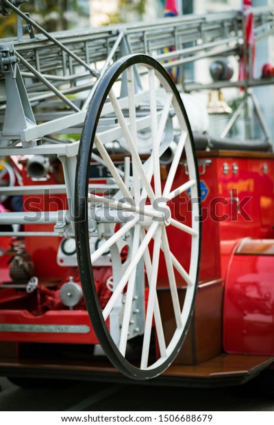 Close up of a vintage fire truck fire hose wheel\
in white.