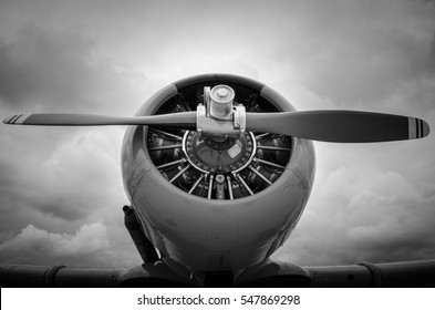 Close Up Of A Vintage Prop Plane Shot In Black & White With Dramatic Clouds In The Background