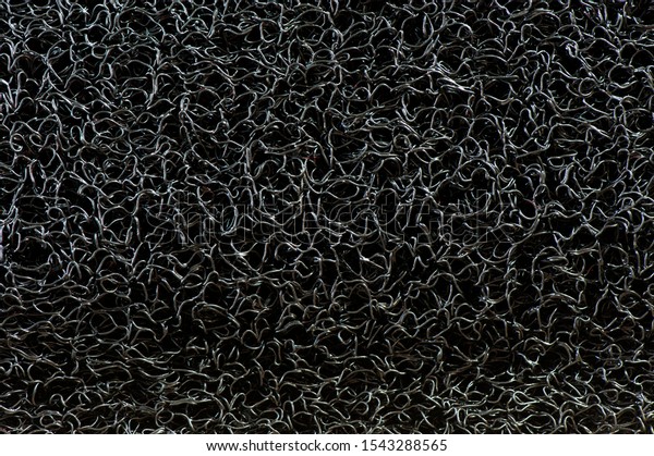 Close up of Vinyl dust trap carpet texture\
background. Abstract background concept for pattern and design.\
Industrial black vinyl carpet Coil Pattern Car Floor Mat texture.\
anti slippery surface