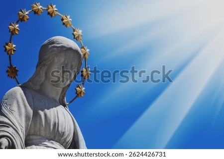 Close up Virgin Mary against blue sky. Fragment of ancient statue. Religion, faith, Christianity concept.