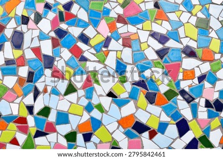 Close up of wall made of irregular small colorful mosaic stones, uneven textured decorative surface with vibrant pattern