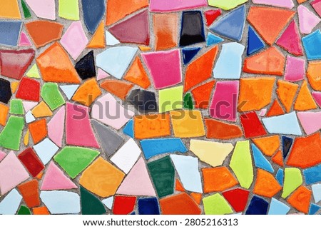 Close up of wall made of irregular small colorful mosaic stones, uneven textured decorative surface with vibrant pattern