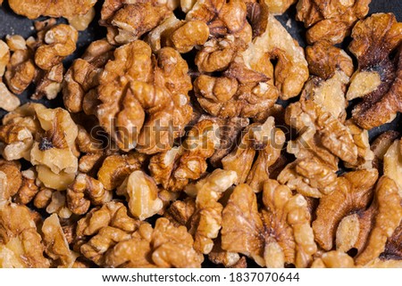 Close up of walnuts in dark grey cast iron pan for roasting spices