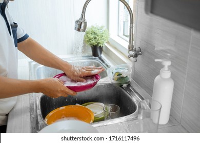 close up of washes dishes with a sponge in the sink
