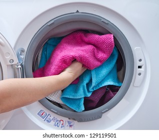 A Close Up Of A Washing Machine Loaded With Clothes