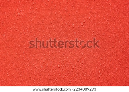 Close up water drops on red leather, background.