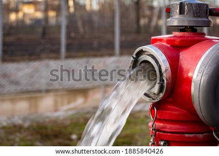 Close up of Water flowing from in open red fire hydrant