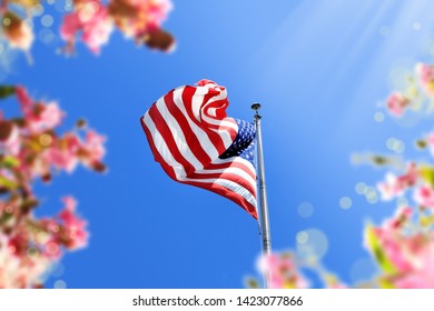 close up waving American flag and flowers over blue clear sky