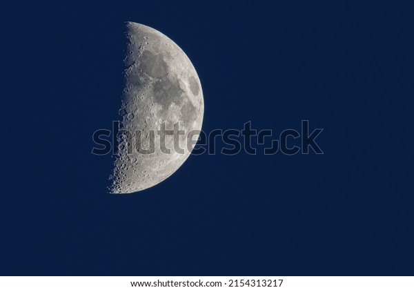 a\
close up of the waxing crescent moon in the blue\
sky