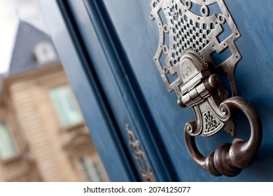 Close up of a weathered knocker on a wooden door