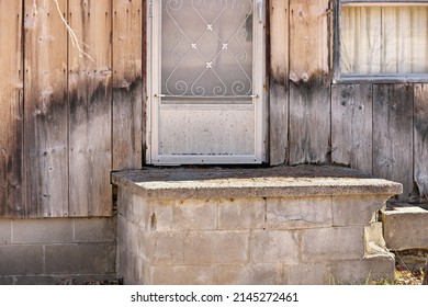 Close Up Of Weathered Wood Siding Beginning To Rot Around Front Step Of Cottage Or House